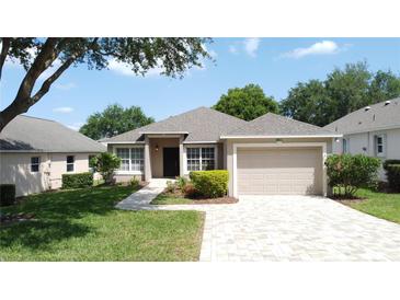 Charming single Gathering home with a well-manicured lawn, brick driveway, and two-car garage at 2160 Addison Ave, Clermont, FL 34711
