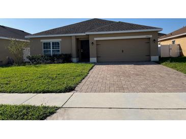 Charming single-story home with a brick paver driveway and well-maintained lawn at 2802 Glendive Dr, Kissimmee, FL 34758