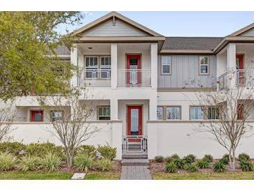 Charming two-story home with a welcoming red door and nicely landscaped front yard at 7059 Nemours Pkwy, Orlando, FL 32827
