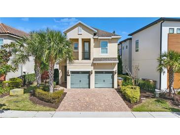 Two-story home with a brick driveway, a two-car garage and manicured landscaping at 785 Desert Mountain Ct, Reunion, FL 34747