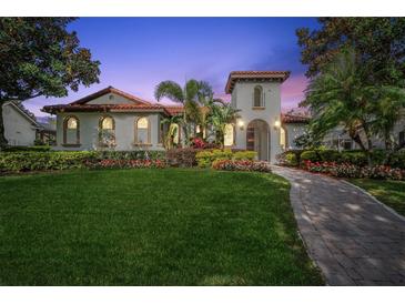 Charming Mediterranean-style home with lush landscaping, a tile roof, and a brick walkway at 8437 Lake Burden Cir, Windermere, FL 34786