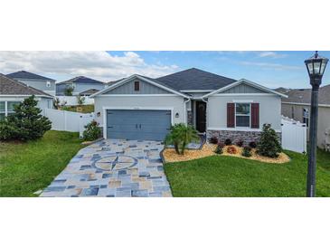 Charming single-Gathering home with a blue garage door, stone accents, and decorative driveway at 9158 Elsa Ct, Davenport, FL 33897