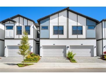 Modern townhome exterior with neutral paint, updated roofing, and private driveways at 10287 Ebb Tide Lane, Orlando, FL 32821