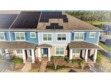 Charming townhome featuring solar panels, a covered porch, and inviting curb appeal at 10394 Spring Arbor Ln, Winter Garden, FL 34787