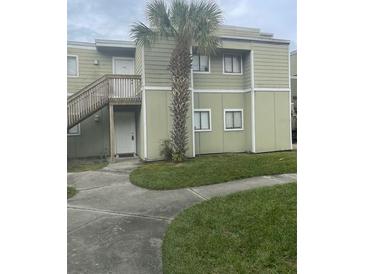 Charming two-story home with a well-maintained lawn and walkway to front door at 145 Scottsdale Sq # 145, Winter Park, FL 32792