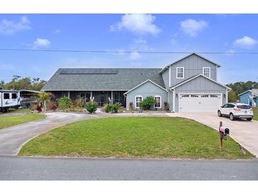 Charming two-story home with landscaped yard, solar panels, and circular driveway on a sunny day at 2086 Blackfoot Trl, St Cloud, FL 34771