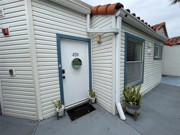 Apartment 203 exterior with potted plants and storm door at 2560 Woodgate Blvd # 203, Orlando, FL 32822