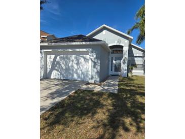 Charming single Gathering home featuring an attached garage, palm tree and well-maintained lawn at 334 Sonja Cir, Davenport, FL 33897