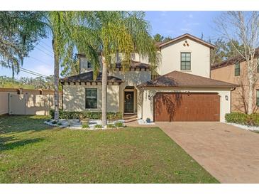 Charming two-story home with brick driveway, manicured lawn, and tropical landscaping at 5201 Lake Hinden Cv, St Cloud, FL 34771