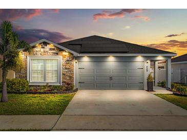Charming home featuring a two-car garage, stone accents, solar panels and a well-manicured lawn at 669 Persian Dr, Haines City, FL 33844