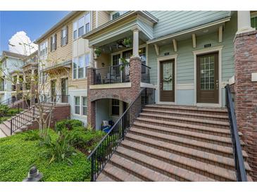 Multi-unit townhouse with a brick staircase leading to covered porches and well-manicured landscaping at 840 Luarca Ln, Oviedo, FL 32765