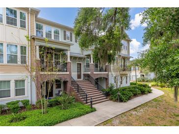Charming multi-story condo with brick accents, a covered porch, and lush landscaping at 840 Luarca Ln, Oviedo, FL 32765