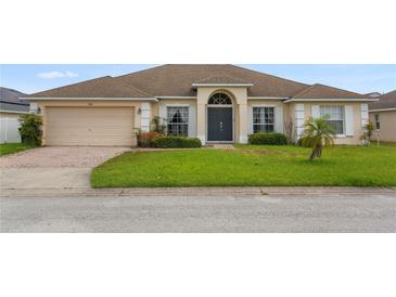 Charming single-story home featuring a well-manicured lawn and a two-car garage at 152 Moscato Dr, Davenport, FL 33897