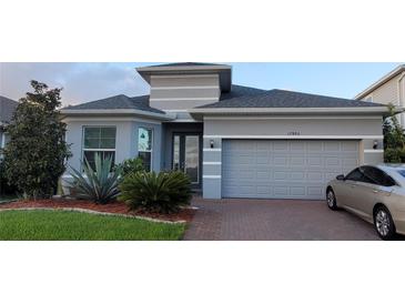 Beautifully landscaped single-Gathering home with a brick-paved driveway and a two-car garage at 17880 Passionflower Cir, Clermont, FL 34714