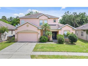 Charming two-story home with a well-manicured lawn and attached two-car garage at 2165 The Oaks Blvd, Kissimmee, FL 34746