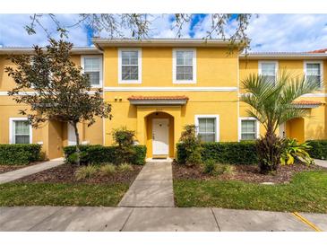 Charming yellow townhome with lush landscaping, sidewalk, and a welcoming entrance at 3055 Yellow Lantana Ln, Kissimmee, FL 34747
