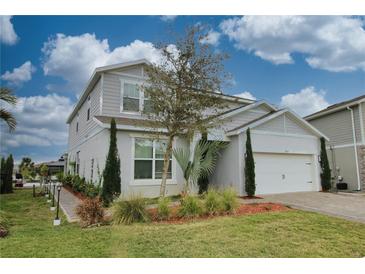 Charming two-story home showcasing landscaped front yard, attached two-car garage, and craftsman design details at 3262 Hanging Tide St, Winter Garden, FL 34787