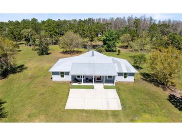 Stunning ranch-style home featuring a metal roof, well-manicured lawn, and a spacious front porch at 5801 N Kenansville Rd, St Cloud, FL 34773