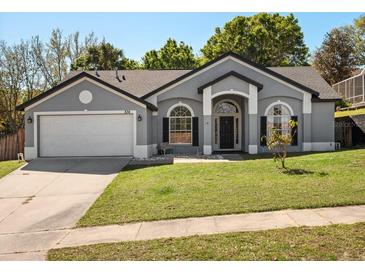 Charming single-story home featuring a well-manicured front lawn and attached two-car garage at 834 High Pointe Cir, Minneola, FL 34715