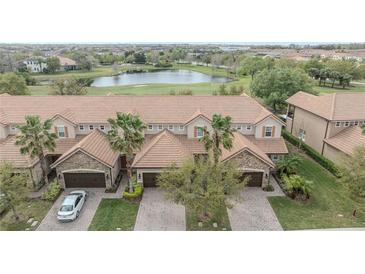 Beautiful townhome with tile roof, two-car garage, brick driveway, and views of the golf course and pond at 10731 Belfry Cir, Orlando, FL 32832