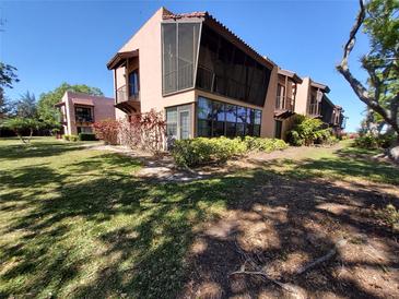 Charming condo exterior featuring a screened-in porch and well-maintained landscaping, perfect for outdoor living at 133 La Casa # 133, Lake Wales, FL 33898