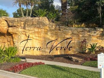 Terra Verde's entrance sign with beautiful stonework and landscaping at 4726 Ormond Beach Way, Kissimmee, FL 34746