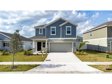 Charming two-story home featuring a covered entry, two-car garage, and beautifully landscaped front yard at 606 Bell Prairie Cir, Lake Wales, FL 33859