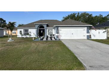 Charming single-story home with well-maintained lawn, inviting entrance and two car garage at 633 Kangaroo Dr, Kissimmee, FL 34759