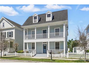 Inviting two-story home featuring double porches and a well-maintained lawn, exuding classic charm at 205 Norfolk Pl, Celebration, FL 34747