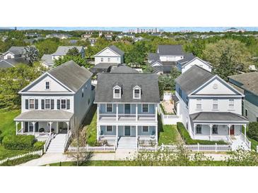 Charming two-story home with a welcoming front porch, white picket fence, and well-manicured lawn at 205 Norfolk Pl, Celebration, FL 34747