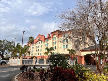 Attractive exterior of the hotel on a sunny day with lovely landscaping and mature trees at 3000 Maingate Ln # 330, Kissimmee, FL 34747