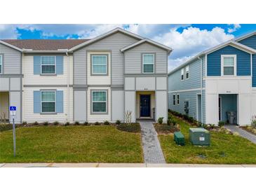 Charming townhome with a well-manicured lawn and welcoming entrance showcases the exterior of the home at 4002 Lana Ave, Davenport, FL 33897
