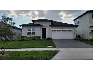 Beautiful single-story home featuring a modern design, manicured lawn, and attached two-car garage at 4952 Shady Pines Dr, St Cloud, FL 34772