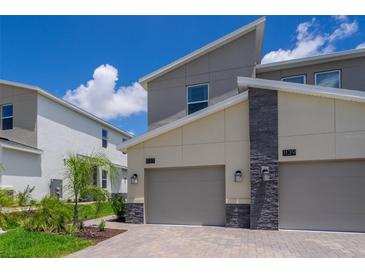 Modern home exterior showcasing clean lines, neutral colors, and attached garages with a well-maintained front yard at 1137 Drop Ln # 1137, Davenport, FL 33896