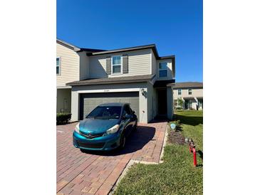 Charming two-story home with a well-maintained front yard and a brick-paved driveway at 2040 Milkweed St, Ocoee, FL 34761