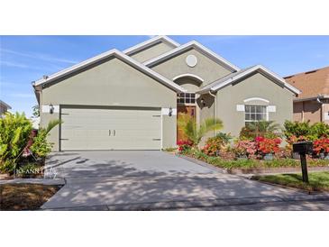 Charming single-story home featuring a lush, landscaped front yard and a two-car garage at 2102 Congress Ln, St Cloud, FL 34769