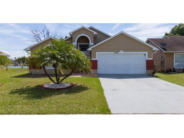 Inviting single Gathering home showcasing well-manicured lawn, 2 car garage, and beautiful landscaping at 2150 Flintlock Blvd, Kissimmee, FL 34743