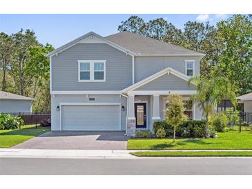 Beautiful two-story home with a manicured lawn, neutral paint, and a two-car garage at 3010 Camden Way, Davenport, FL 33837