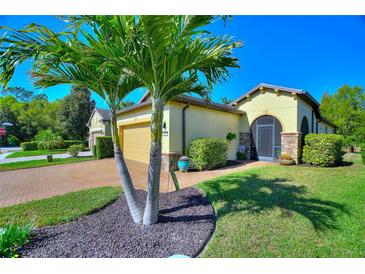 Beautiful home with a well manicured lawn and lush landscaping, including mature palm trees at 104 La Cresta Ct, Davenport, FL 33837
