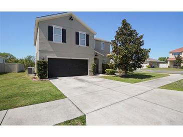 Charming two-story home featuring a spacious driveway, a well-maintained lawn, and a beautifully landscaped yard at 1246 Maplebrook Dr, Lake Alfred, FL 33850