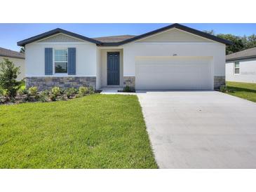 Charming single-story home with a well-maintained lawn and stone accents, complemented by a modern two-car garage at 1249 Oak Valley Dr, Auburndale, FL 33823