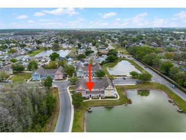 Aerial view of charming lakeside townhomes, featuring lush landscaping and serene water views at 2200 San Vittorino Cir # 105, Kissimmee, FL 34741