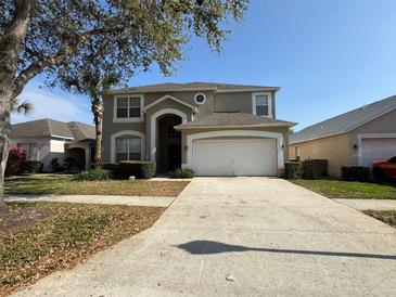 Charming two-story home featuring a two-car garage and well-maintained landscaping in a residential neighborhood at 2677 Emerald Island Blvd, Kissimmee, FL 34747