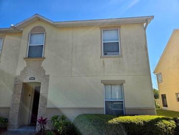 Two-story townhouse exterior featuring a decorative facade and well-maintained landscaping at 2706 Club Cortile Cir, Kissimmee, FL 34746