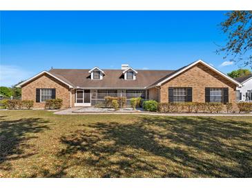 Charming brick home featuring dormer windows, mature landscaping, and manicured lawn at 3161 Appaloosa Ct, Kissimmee, FL 34746