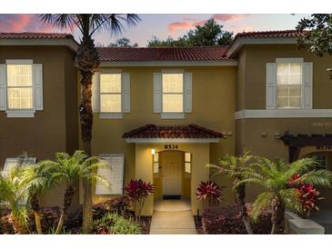Charming townhouse with a stucco facade, red tile roof, and well-manicured landscaping at 8534 Crystal Cove Loop, Kissimmee, FL 34747