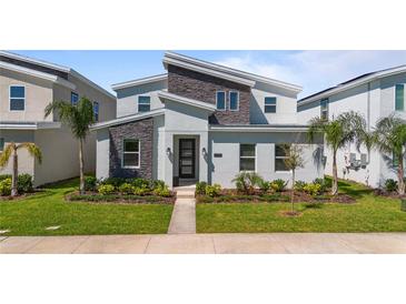 Modern two-story home with landscaped yard, stone accents, and contemporary design features at 9190 Sommerset Hills Dr, Davenport, FL 33896