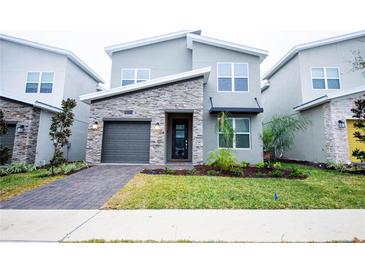 Modern two-story home with stone accents, landscaped yard, and a one-car garage at 1025 Leader St, Davenport, FL 33896