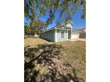 Single-story home with a two car garage and a well-maintained, grassy front lawn at 1149 E Grove Ave, Lake Wales, FL 33853