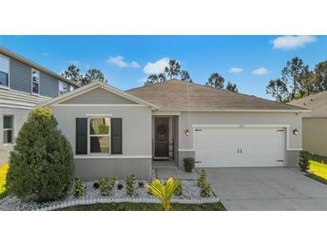 Charming single-story home with a well-manicured lawn and attached two-car garage at 1153 Augustus Dr, Davenport, FL 33896